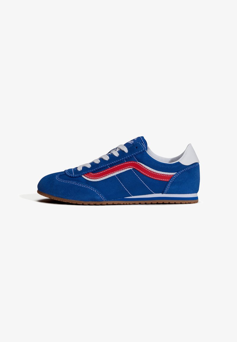 Basket en daim bleu avec lacets blancs, détail rayé rouge et blanc, talon blanc et semelle en caoutchouc marron, vue de côté.