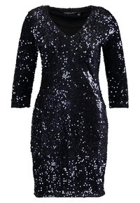 Abito nero in paillettes con scollo a V e maniche a tre quarti. Il tessuto è ricoperto da paillettes lucide e riflettenti che creano un effetto strutturato.