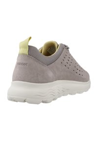 Zapatillas de ante gris con acentos de malla y perforaciones. Lengüeta del talón de color amarillo claro. Suela de goma blanca con patrón en forma de ola para mayor agarre.