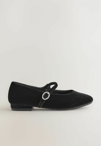 Pantofii de balet din catifea neagră, cu vârful rotund, toc plat și o curea decorativă care are un accent circular din argint.