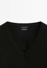 Black wool-cashmere sweater featuring a V-neck design, ribbed collar, and smooth texture, with care label visible inside the neckline.