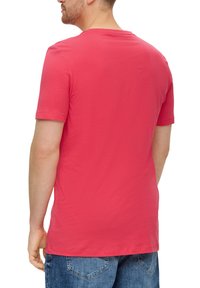 Korte mouwen, ronde hals T-shirt in helder koraal katoen. Soepele textuur, ontspannen pasvorm en rechte zoom. Draag het met blauwe denim shorts.