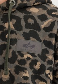Felpa con cappuccio a stampa leopardata verde e marrone, con cordino verde e patch rettangolare del logo Alpha Industries sul petto.