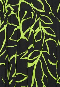 Tessuto nero con un audace motivo astratto a foglia in un vivace verde neon. La texture appare liscia con leggere pieghe.