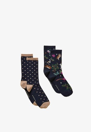To par navyblå sokker, den ene med lysebrune prikker og hæle, den anden med farverige dyre- og blomstertryk.