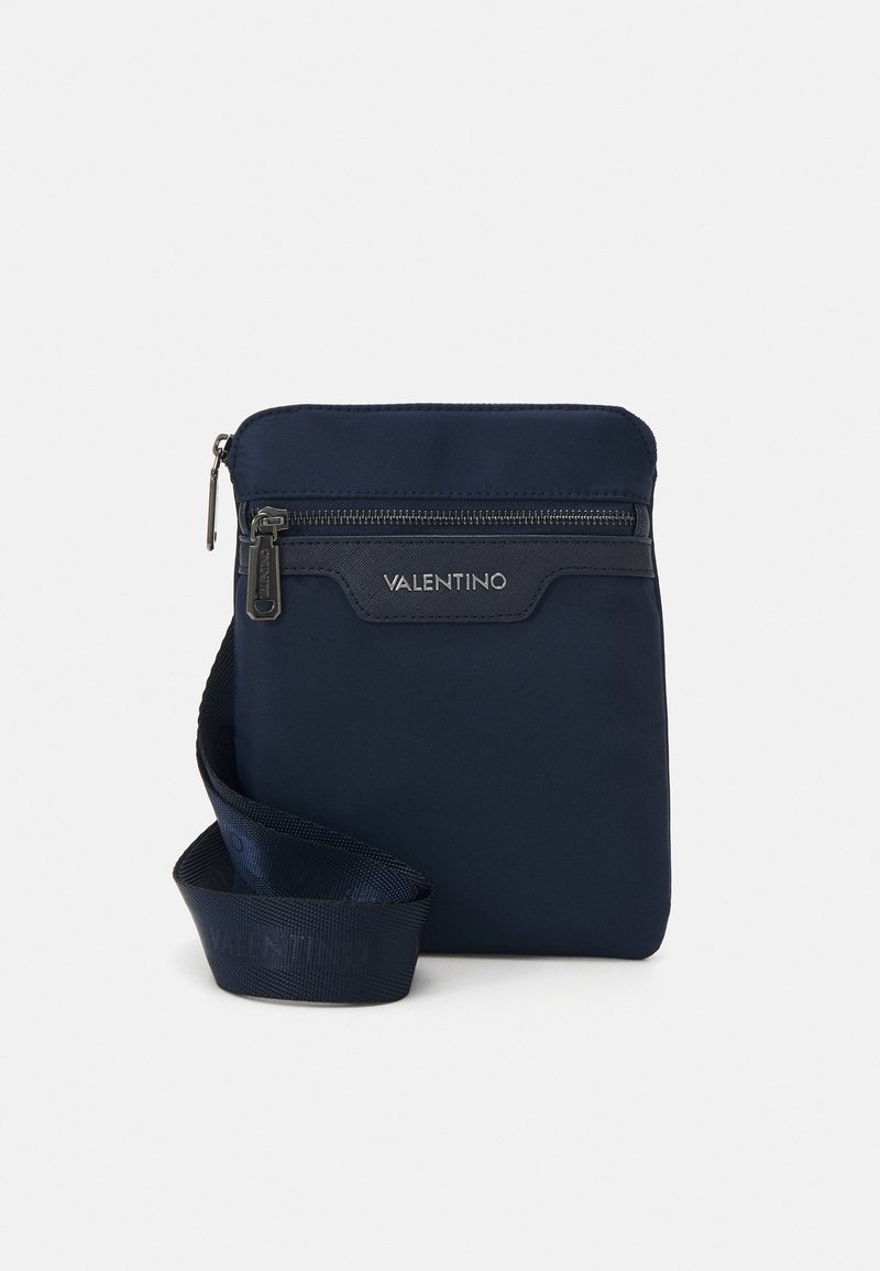 Borsa a tracolla in nylon blu con zip superiore, dettaglio logo sulla parte anteriore e tracolla texturizzata. Forma rettangolare compatta con superficie liscia.