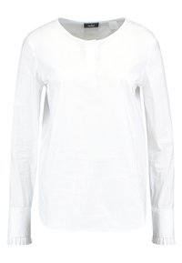 Blouse blanche à manches longues avec un col rond, patte de boutonnage et détails de poignets plissés. Fabriquée en tissu léger et lisse.