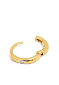 Anello in metallo color oro con design liscio e arrotondato e un'unica pietra preziosa trasparente come decorazione. Aperto sul retro per una vestibilità regolabile.