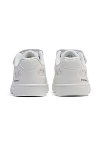 Białe skórzane trampki o gładkim wykończeniu, zaokrąglonym czubku, teksturowanych akcentach na pięcie oraz napisie "ST. POWER PLAY" wydrukowanym z boku.