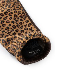 Guante de cuero con estampado de leopardo marrón y negro, con muñequera elástica y etiqueta de la marca Roeckl München visible en el interior.