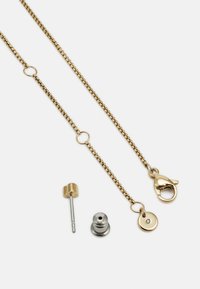Catena color oro con chiusura a gancio e accenti circolari, include due componenti metallici accompagnatori per attacco o regolazioni.
