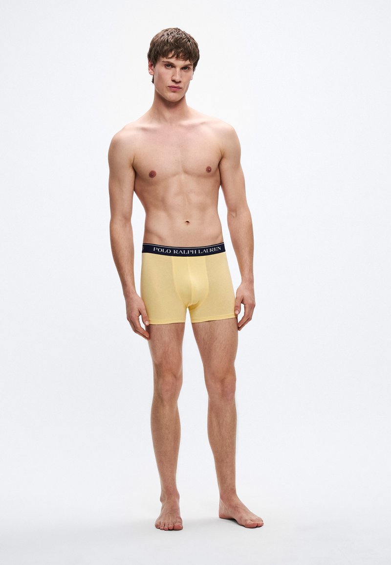 Žlté bavlnené boxerky s čiernym pásom s logom "POLO RALPH LAUREN", priliehavý strih a krátka dĺžka nohavičiek.