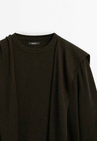 Pull en laine marron foncé avec un col rond et une épaule structurée, présentant une texture lisse. Étiquette visible à l'intérieur du col.