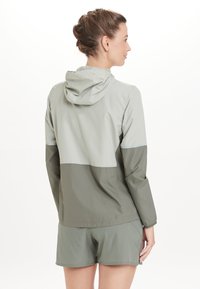 Lichte, gewatteerde jacket met capuchon in een two-tone grijs ontwerp met een gladde textuur en contrasterende secties. Heeft een ontspannen pasvorm en ademende stof.