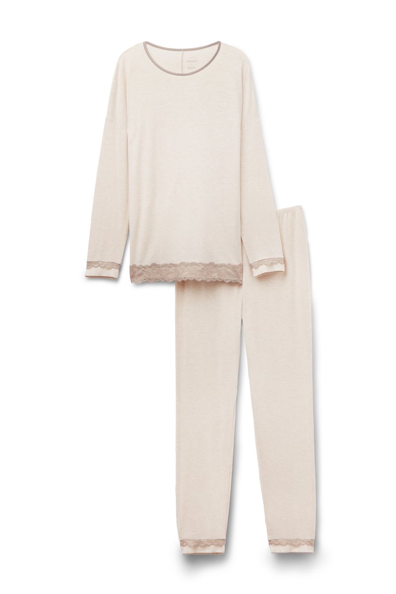 Beige långärmad topp och byxset gjort av mjukt tyg, med spetsdetaljer vid ärmslut och nederkant. Enkelt, avslappnat design.
