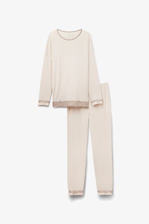 Conjunto de pijama color beige claro con camiseta de manga larga y pantalones, con detalles de encaje en los puños y el dobladillo. Tejido suave y liso, ajuste relajado.