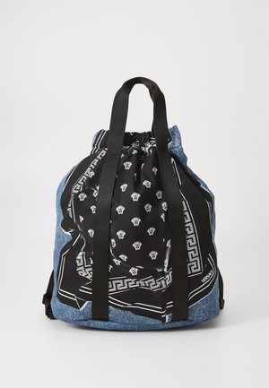Džínový batoh so šnúrkou, s čiernym potlačeným bandana vrchom, ktorý má čierne popruhy a biele logá a akcenty Versace.