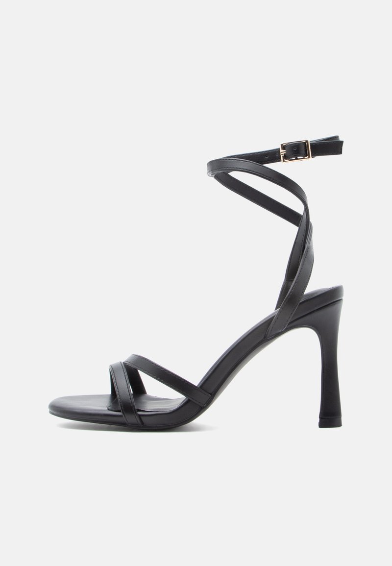 Mustad kõrge kontsaga sandaalid, millel on sile disain, kahte kitsast rihma varba kohale ja ristatud pahkluu rihm koos pandlaga.
