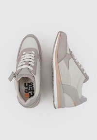 Zapatillas gris claro con materiales de ante y cuero, con un acabado texturizado, cordones blancos y una suela en un marrón claro contrastante.