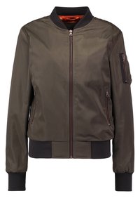 Veste bomber vert olive avec col, poignets et ourlet côtelés noirs, équipée de poches zippées à l'avant et sur les manches, avec une doublure orange.