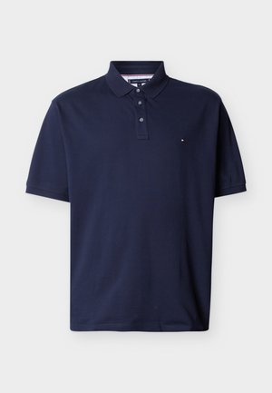 Marineblaue Poloshirt mit kurzen Ärmeln, drei Knöpfen und einem kleinen weißen, roten und marineblauen Logo auf der Brust.