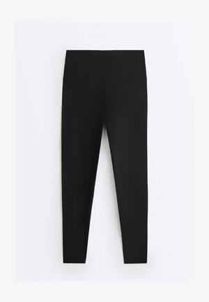 Fekete, derékban magasított leggings sima derékrésszel, fehér háttéren laposan elrendezve.