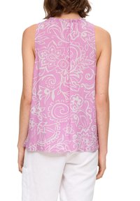 Top senza maniche in tessuto rosa chiaro con motivi floreali e swirl bianchi. Presenta un collo arricciato e un orlo dritto.