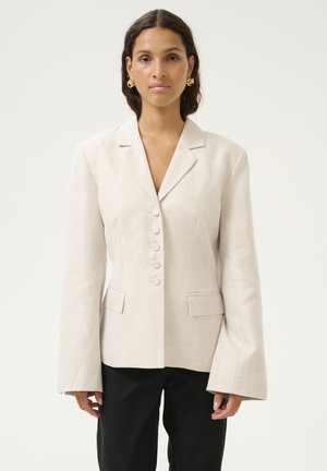 Blazer in lino beige con una silhouette fitted, rever a punta, chiusura con bottone monopetto e maniche lunghe a campana. Due tasche frontali.