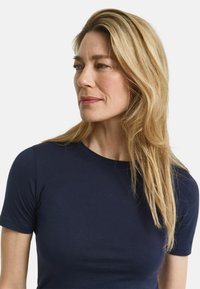 Marineblaue Kurzarm-T-Shirt aus weichem Stoff. Schlichtes Design mit Rundhalsausschnitt und taillierter Silhouette.