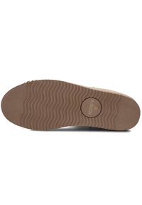 Schoenzool met een getextureerd bruine rubberen oppervlakte, voorzien van golvende patronen en een afgeronde rand. Gemarkeerd met "NOTRE-V 38" in het midden.