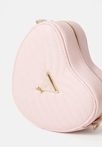 Case cosmetico a forma di cuore imbottito rosa realizzato in materiale sintetico, con un accento del logo in tonalità oro e chiusura con zip.