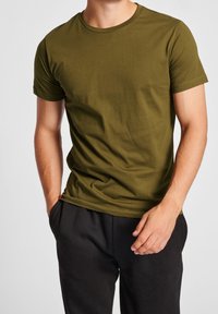 Olivengrøn T-shirt med korte ærmer lavet af blød bomuld, med klassisk rund halsudskæring og slank pasform. Tekstureret stof uden mønstre.