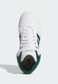 Białe buty sportowe z zielonymi akcentami i trzema paskami. Posiadają perforowaną wstawkę na palcach i białe sznurowadła. Logo znajduje się na języku i pięcie.