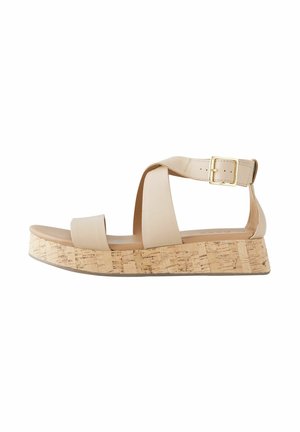 Beige Plateau-Sandalen mit einem Kork-Blockabsatz, ausgestattet mit breiten Überkreuzriemen und einer Metall-Schnalle am Knöchelriemen.