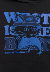 Graphique bleu d'un chat portant un chapeau tenant un poisson dans la bouche avec le texte « WIT IS BEAT » et « hunter instinct » sur un tissu noir.