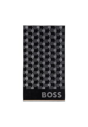 Écharpe à carreaux noirs et gris avec un motif rectangulaire et le mot "BOSS" en grandes lettres à une extrémité.