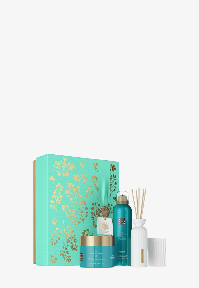 Boîte cadeau florale turquoise et dorée contenant une crème pour le corps, un gel douche moussant, un diffuseur de parfum en bâtonnets et un porte-bougie blanc.