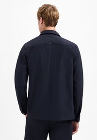 Marineblauw jack met kraag, lange mouwen en een gladde textuur. Voorzien van een achterventiel met een decoratieve knoop. Minimalistisch ontwerp.