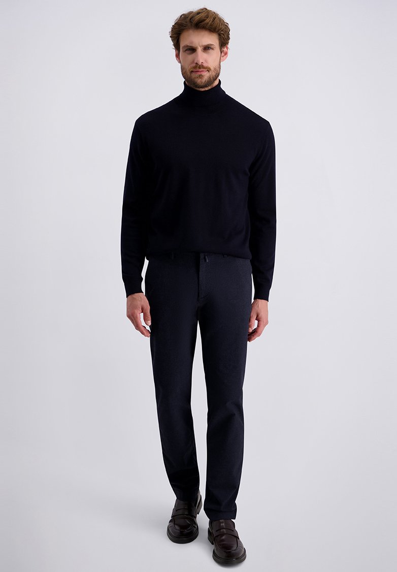 Marineblauwe coltrui en donkere broek, beide nauwsluitend. Schoenen zijn donkerbruin met een gladde textuur. Eenvoudig, gestroomlijnd ontwerp.