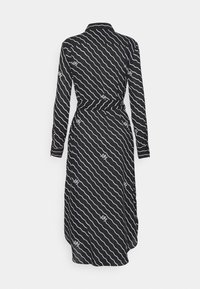 Black dress with long sleeves, collar, and a fitted waist. Features white wavy stripes and a logo pattern, knee-length with a flared hem.