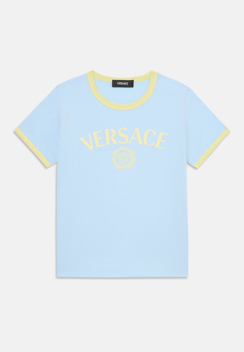 Ljusblå bomullströja med gula detaljer vid halsringningen, med "VERSACE"-logotypen och ett emblem på framsidan. Kortärmad och design med rund hals.