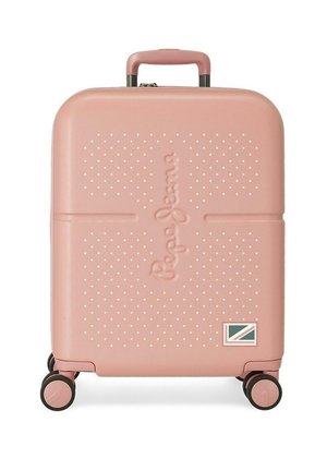 Maleta rígida compacta de color rosa con puntos texturizados, cuatro ruedas, asa retráctil y un pequeño parche con bandera en la esquina inferior derecha.