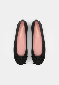 Sapatilhas de balé pretas com um acabamento suave, apresentando um detalhe de laço na ponta e uma palmilha rosa suave, complementadas por um design minimalista.