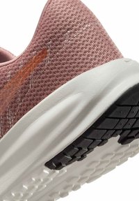 Zapatilla de running de malla rosa con una parte superior texturizada, que presenta una mediasuela blanca y una suela de goma negra con un dibujo en el caucho.