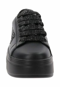 Baskets noires avec une tige en cuir lisse, une languette rembourrée et des lacets noirs pailletés. Elles présentent une épaisse semelle en caoutchouc noire.