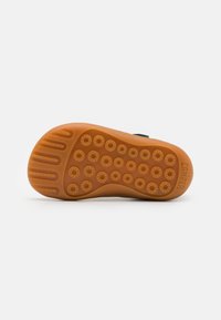 Suola in gomma marrone con motivo di battistrada circolare e scanalature testurizzate, con il logo "Camper" impresso nella zona del tallone.