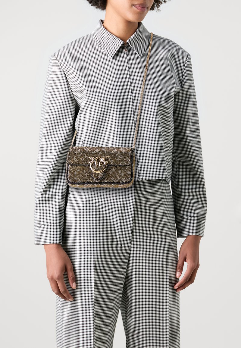 Small rectangular crossbody bag in brown fabric with ornate pattern, gold hardware clasp, and a detachable chain strap.