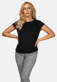 Czarny top z krótkim rękawem i okrągłym dekoltem oraz subtelnym detalem w postaci fałdy, zestawiony z dopasowanymi spodniami w biało-czarny wzór w krateczkę.