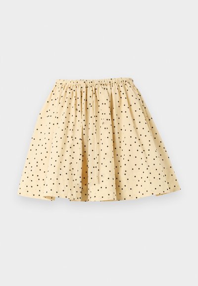 Μπεζ φούστα με μαύρες πουά, ελαστική ζώνη με πιέτες και σχεδιασμό με πλισέ που ανοίγει, απλωμένη σε ανοιχτό φόντο.