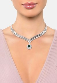 Silver-tone necklace featuring a dual-row design with sparkling clear stones and a central green gemstone accent.